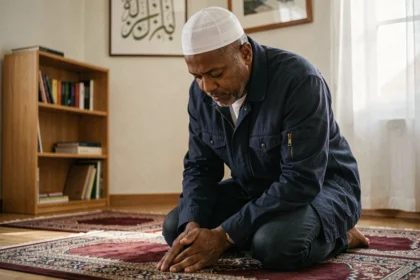 Homme pratiquant la prière du ramadan sur un tapis de prière dans un appartement à Rennes